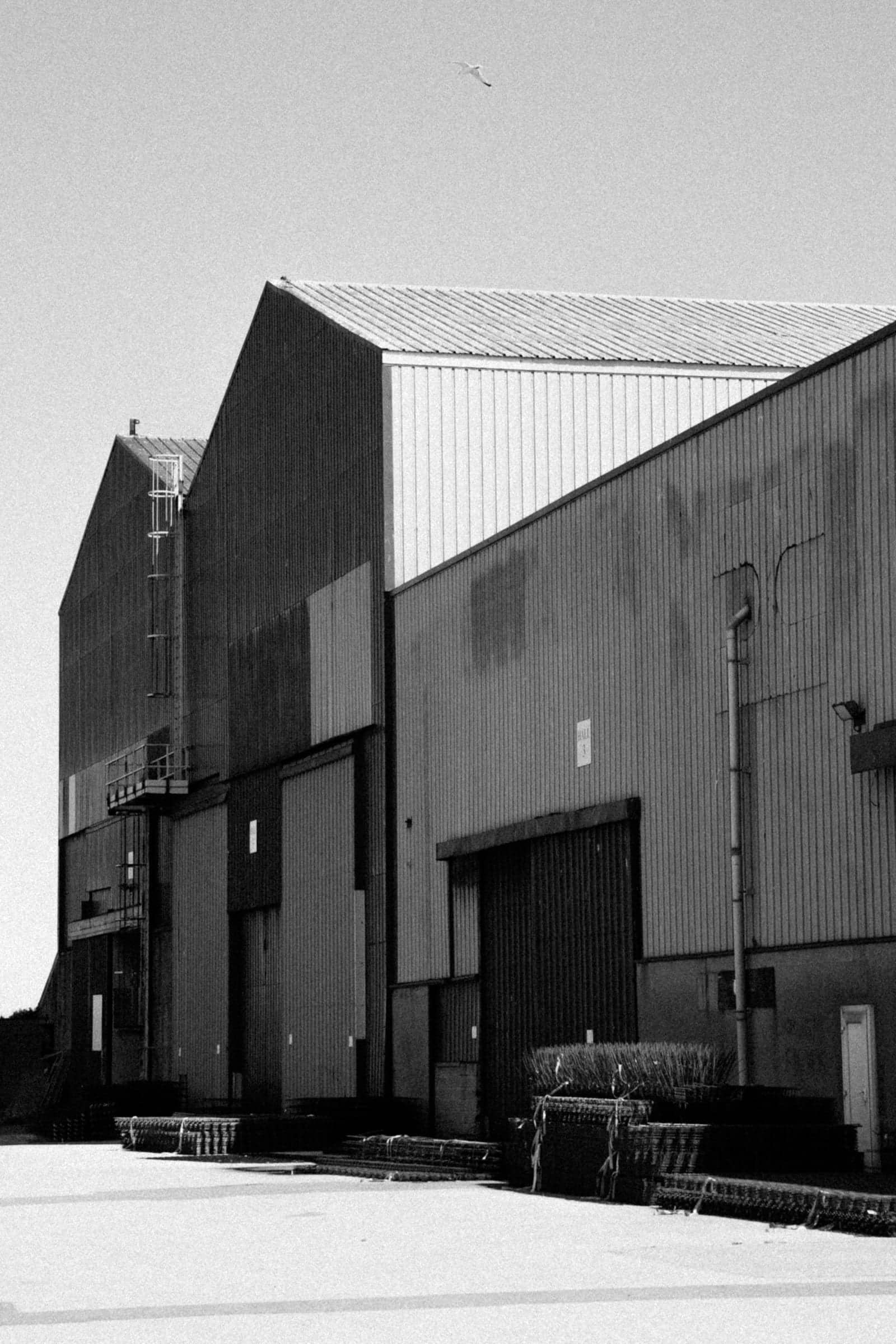 A finished metal building with steel cladding and a large roll-up door on a cleared site