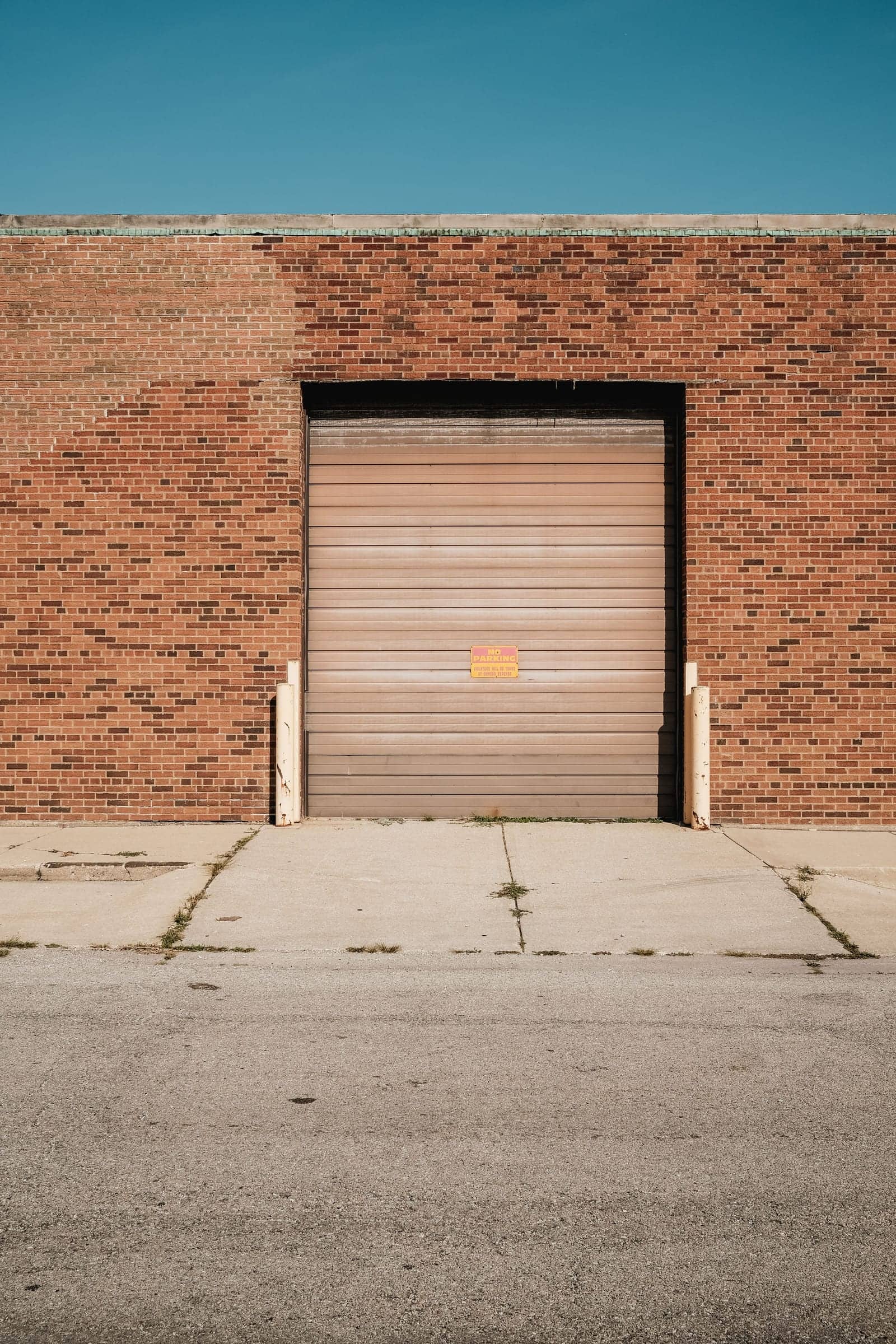 An industrial metal building exterior with a closed garage door
